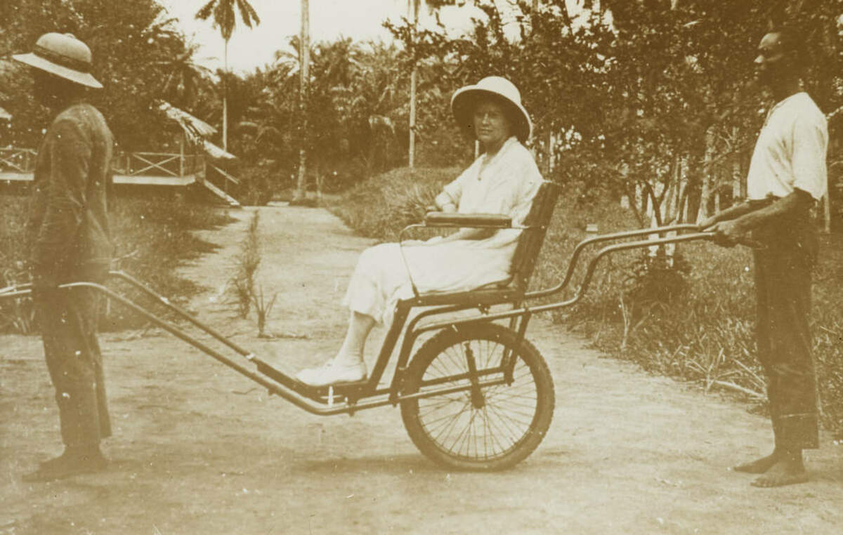 Commissio Plus de détails  Une missionnaire tirée dans un rickshaw par des hommes congolais, environ 1920-1930. Domaine publicn au parlement belge (DR)
