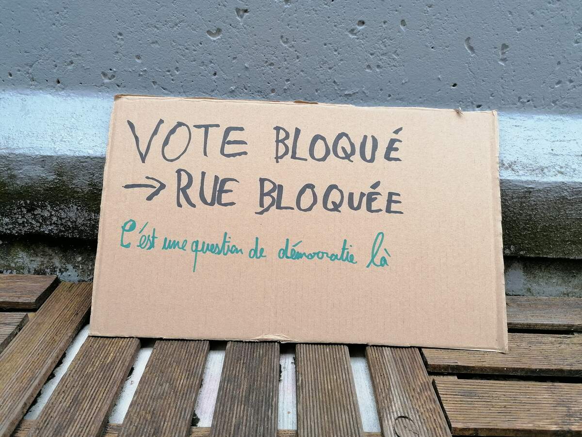 Pancarte brandie lors d’une journée de manifestation nationale, le 11 mars 2023 à Bourgoin-Jallieu (Isère), contre le projet de réforme des retraites et contre l’utilisation de l’article 44-3 de la Constitution, quelque fois surnommé « article du vote bloqué » par les opposants à la réforme. Via Wikimédia