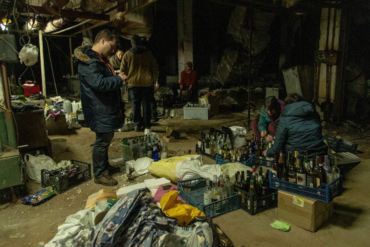  Civils ukrainiens préparant des cocktails Molotov à Kiev le 26 février 2022. Yan Boechat/VOA via Wikimédia