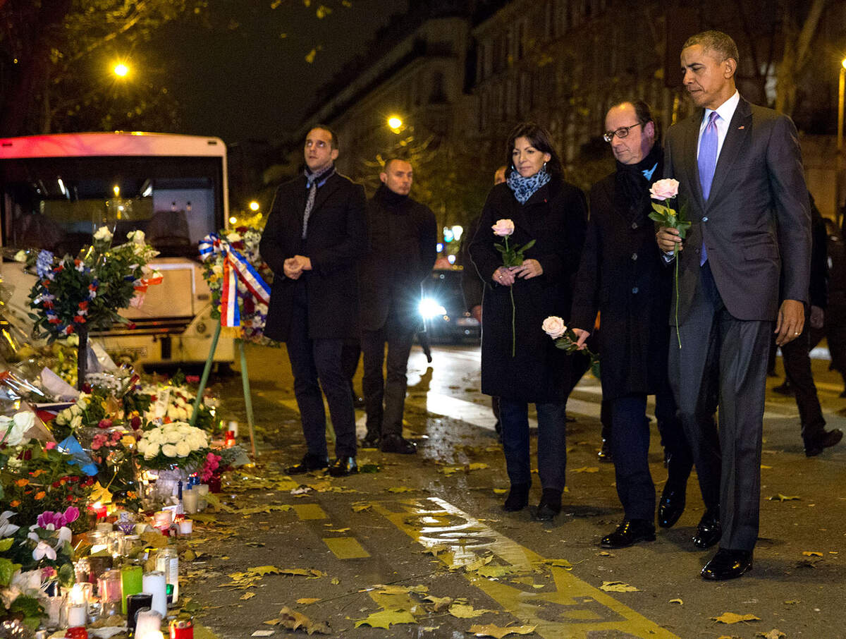 « Après son arrivée en France pour assister au Sommet sur le changement climatique, le président, accompagné du président français François Hollande et de la maire de Paris Anne Hidalgo, a fait une halte imprévue peu après minuit devant le mémorial situé devant le Bataclan, lieu d’un attentat terroriste à Paris. », Photo officielle de la Maison Blanche par Pete Souza, 29 novembre 2015, 18h45, P112915PS-0019