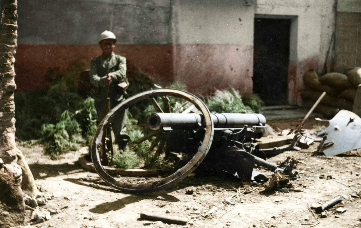 Un soldat se tient derrière un canon détruit, en 1937 © wikimedia commons