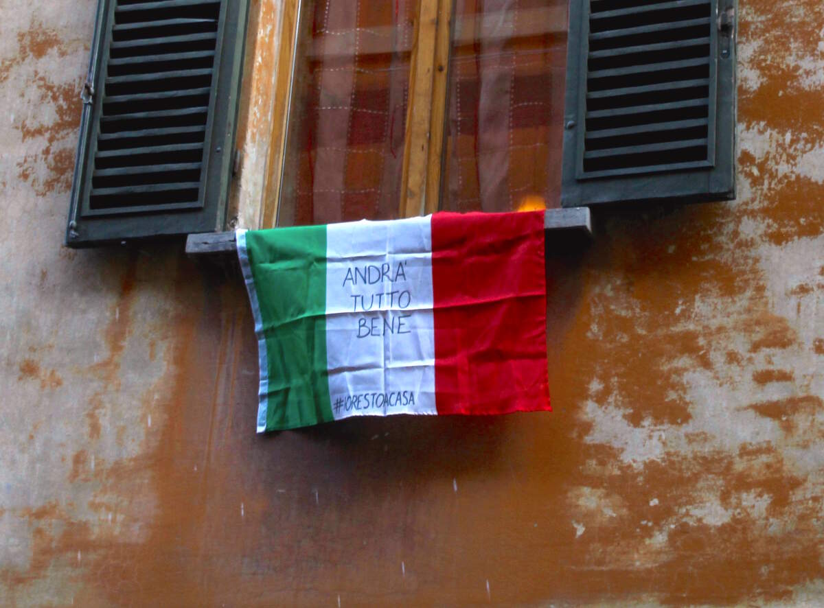 Un drapeau italien accroché à l’extérieur d’une fenêtre à Bologne avec le slogan « Andrà tutto bene » (Tout va bien se passer) pendant la pandémie de Covid-19 en 2020.